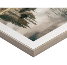 Närbild av en bildram med passepartout och landskapsmotiv