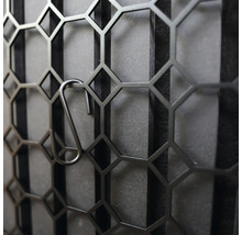 Dekorativ metallvägg med hexagonalt mönster och krokar