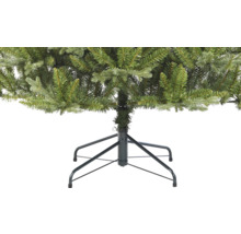 Detaljvy av en konstgjord julgran med metallfot