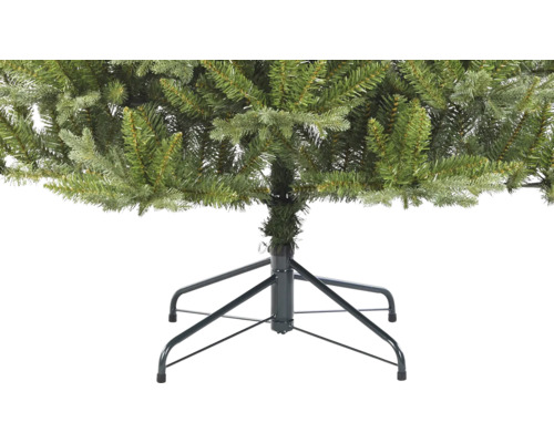 Detaljvy av en konstgjord julgran med metallfot