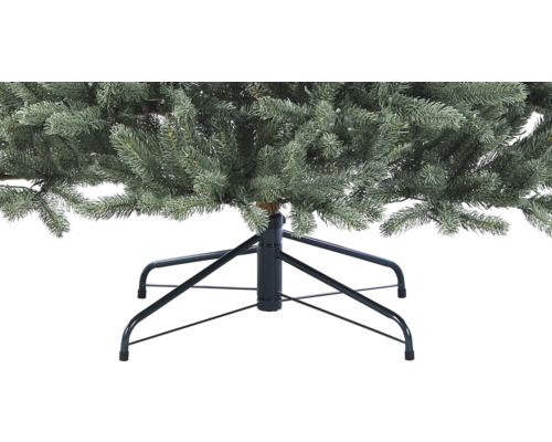 Närbild av en konstgjord julgran med metallfot