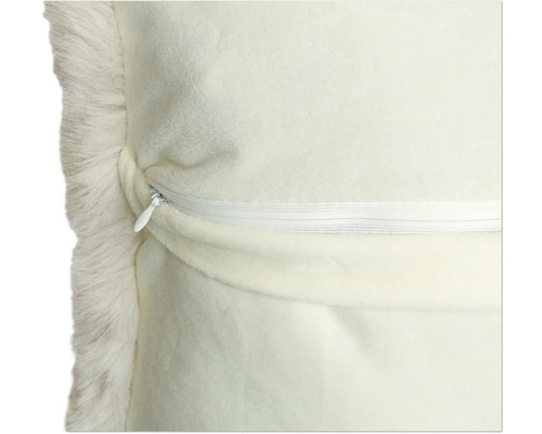 Detaljvy av en kudde med kant av fuskpäls och dragkedja