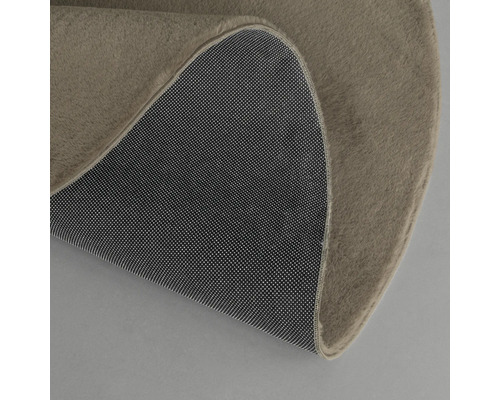 Detalj av en rund matta med textilyta och halkfri undersida