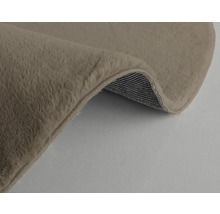 Detaljvy av en beige matta med lugg