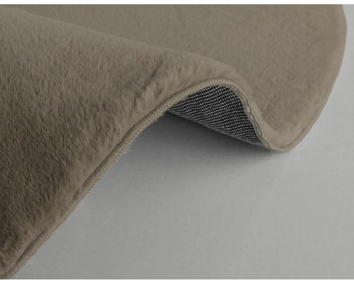 Detaljvy av en beige matta med lugg