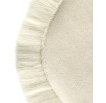 Närbild av en rund matta med dekorativa fransar