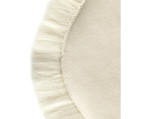 Närbild av en rund matta med dekorativa fransar