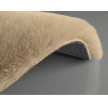 Detaljvy av en beige matta med lugg