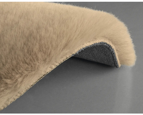 Detaljvy av en beige matta med lugg