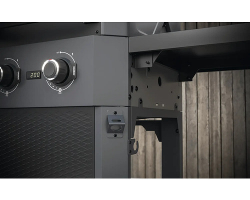 Detaljvy av en kolgrill med temperaturregulator och förvaringsutrymme