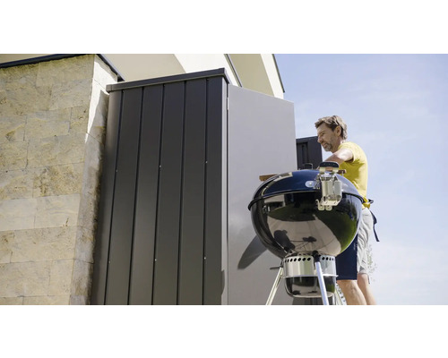 Person förbereder grill, förvaringsutrymme i bakgrunden