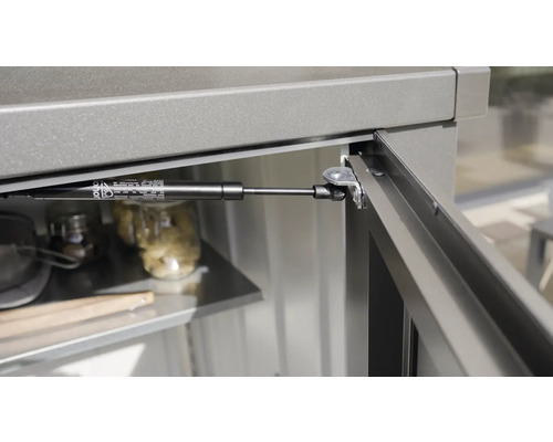 Detaljvy av en gasfjäder på ett utomhusköksskåp