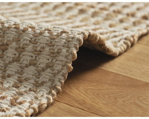 Detaljvy av en flätad matta i naturfiber på ett trägolv
