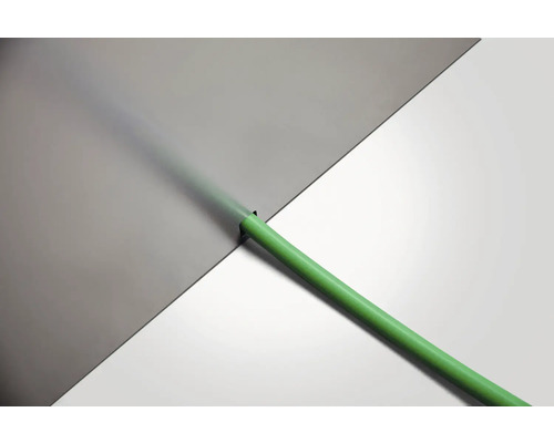 Grön bevattningsslang framför grå och vit yta