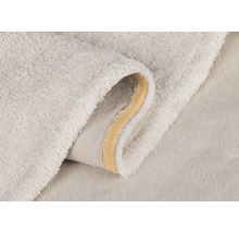 Närbild av en ljus badrumsmatta med mjuk yta