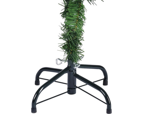 Detaljvy av en konstgjord julgran med metallstativ och gröna plastgrenar.