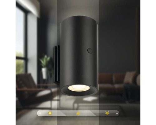 Svart vägglampa i ett vardagsrum