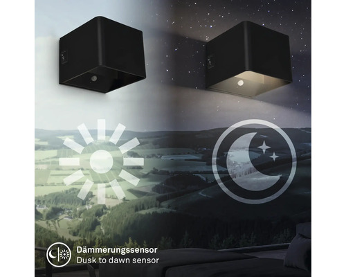Två svarta kubformade vägglampor som visar övergången från dag till natt med skymningssensor.