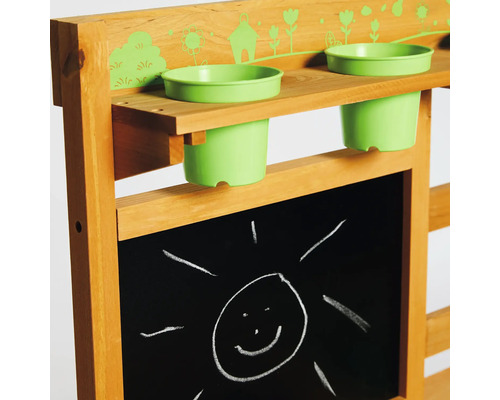 Detaljvy av ett lek-bord för barn med griffeltavla och blomkrukor