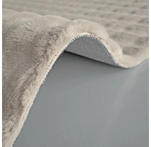 Detaljvy av en grå matta med lugg