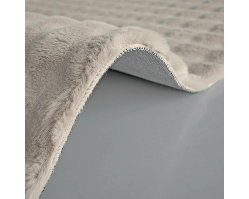 Detaljvy av en grå matta med lugg