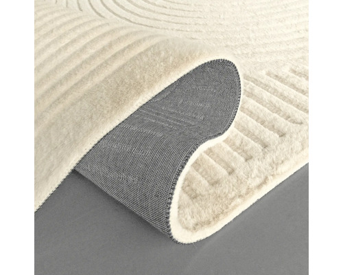 Detaljvy av en beige matta med modernt mönster och textilbaksida