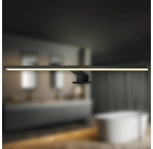 Badrum med en svart LED-vägglampa ovanför ett handfat och ett badkar