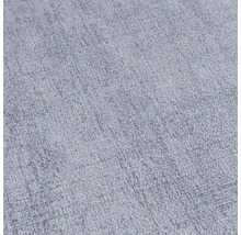 Närbild av ett ljust, texturerat tyg.