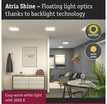 Hall och vardagsrum med taklampor som har bakgrundsbelysning och avger ett varmvitt ljus.