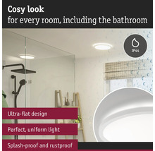 Modernt badrum med platt taklampa, duschkabin och fönster med rullgardin.