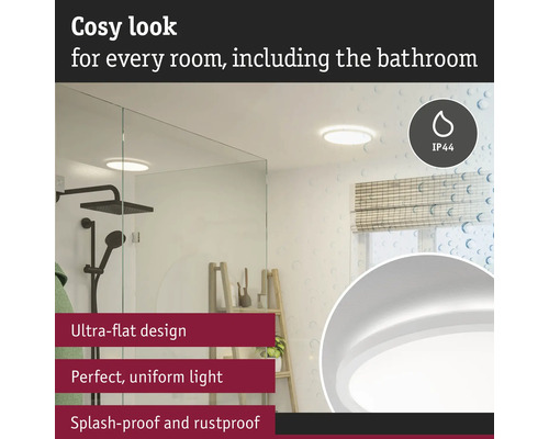 Modernt badrum med platt taklampa, duschkabin och fönster med rullgardin.