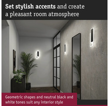 Hall med geometriska vägglampor och spegel