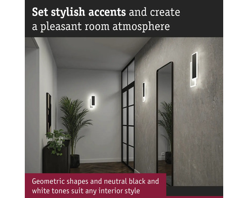 Hall med geometriska vägglampor och spegel