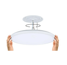 Installationen av en platt LED-taklampa demonstreras med hjälp av händer.