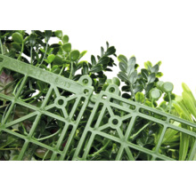 Konstgjord växtvägg med gröna blad och plastgaller