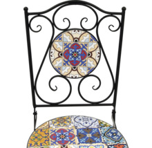 Detaljbild av en stol med kakelmönster och en ram av smidesjärn.