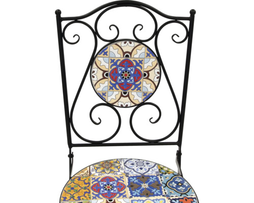 Detaljbild av en stol med kakelmönster och en ram av smidesjärn.