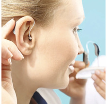 Kvinna sätter in en hörapparat