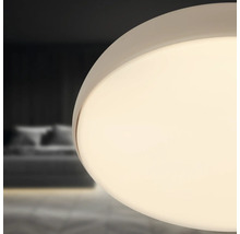 Närbild av en rund taklampa i ett sovrum