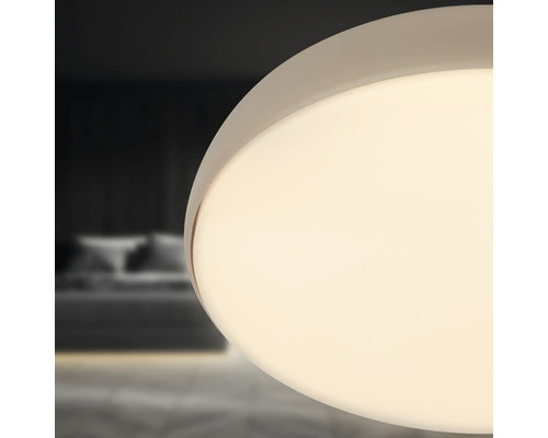 Närbild av en rund taklampa i ett sovrum