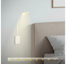 Vägglampa med flexibel läslampa bredvid en säng