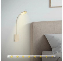 Vägglampa med justerbar ljusstyrka bredvid en säng