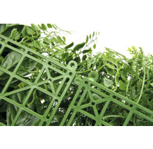 Detaljvy av en konstgjord häck med gröna blad och ett plastgaller