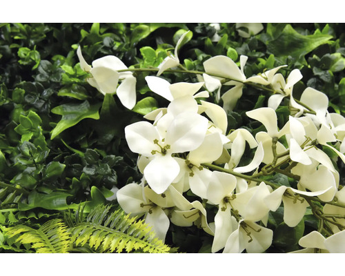 Konstgjord växtvägg med vita blommor och olika nyanser av grönt