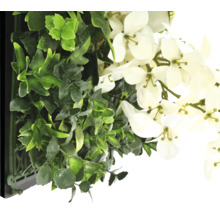 Konstgjord växtvägg med gröna växter och vita blommor