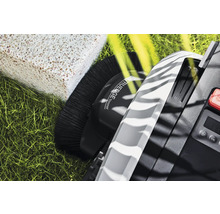 Detaljvy av en robotgräsklippare med kantklippningsfunktion, en borste, en display och en kontrollpanel