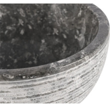 Närbild av en grå blomskål i sten med en räfflad yta.