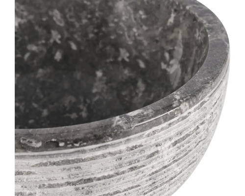 Närbild av en grå blomskål i sten med en räfflad yta.