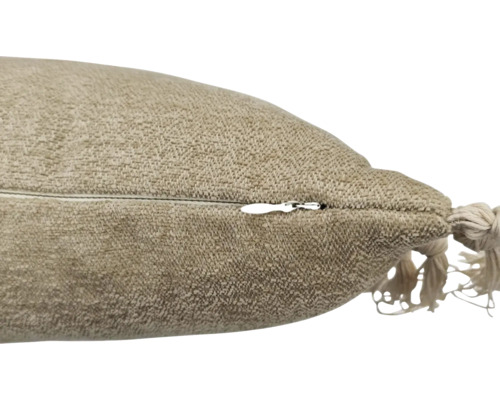 Detaljvy av en kudde med dragkedja och dekorativ tofs