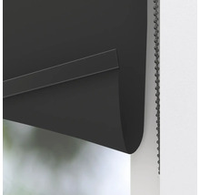 Detaljbild av en svart rullgardin med kedjedrag för fönsterförmörkning.